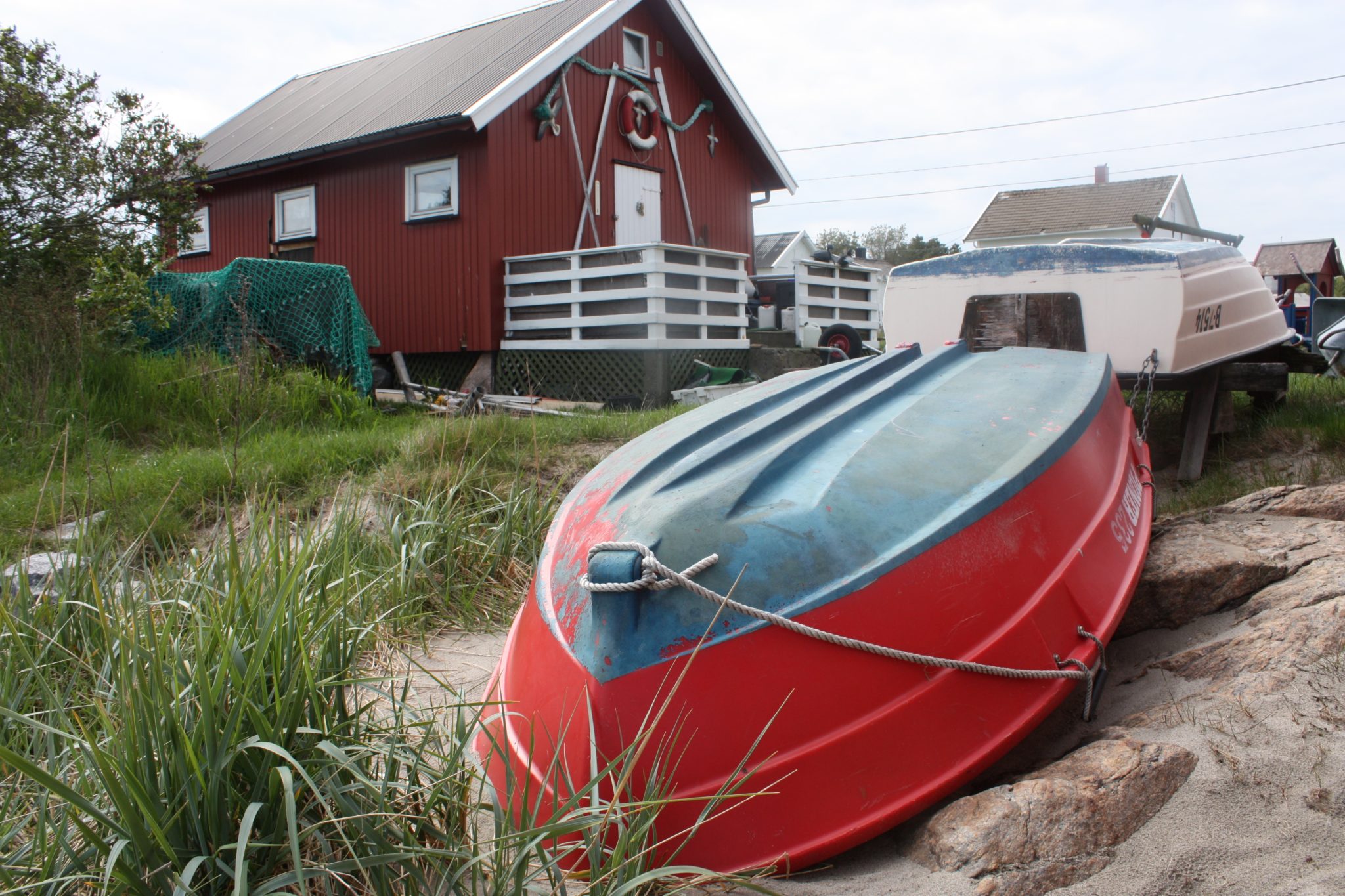 Båter liggende på land i vente av varmegradene på Herføl Marina.